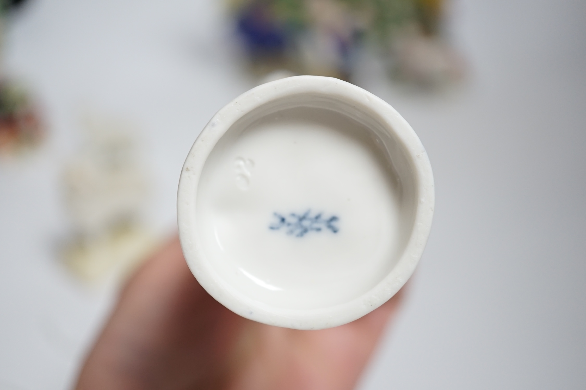 A pair of Derby style porcelain small bocage figures, a boy and girl seated with grape filled hats, height 14cm, three porcelain lambs and another figure